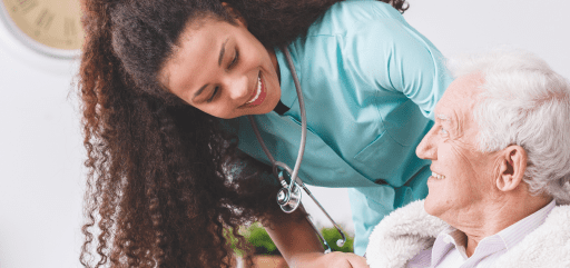 A young nurse smiling with an elderly patient.