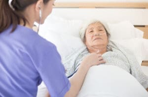 Nurse providing respiratory care to an elderly patient