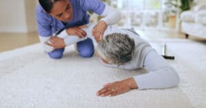 Nurse assessing a fallen resident per their post-fall care management plan.